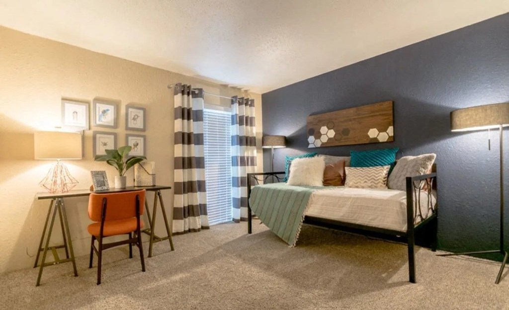 a bedroom with a bed and a desk and a window