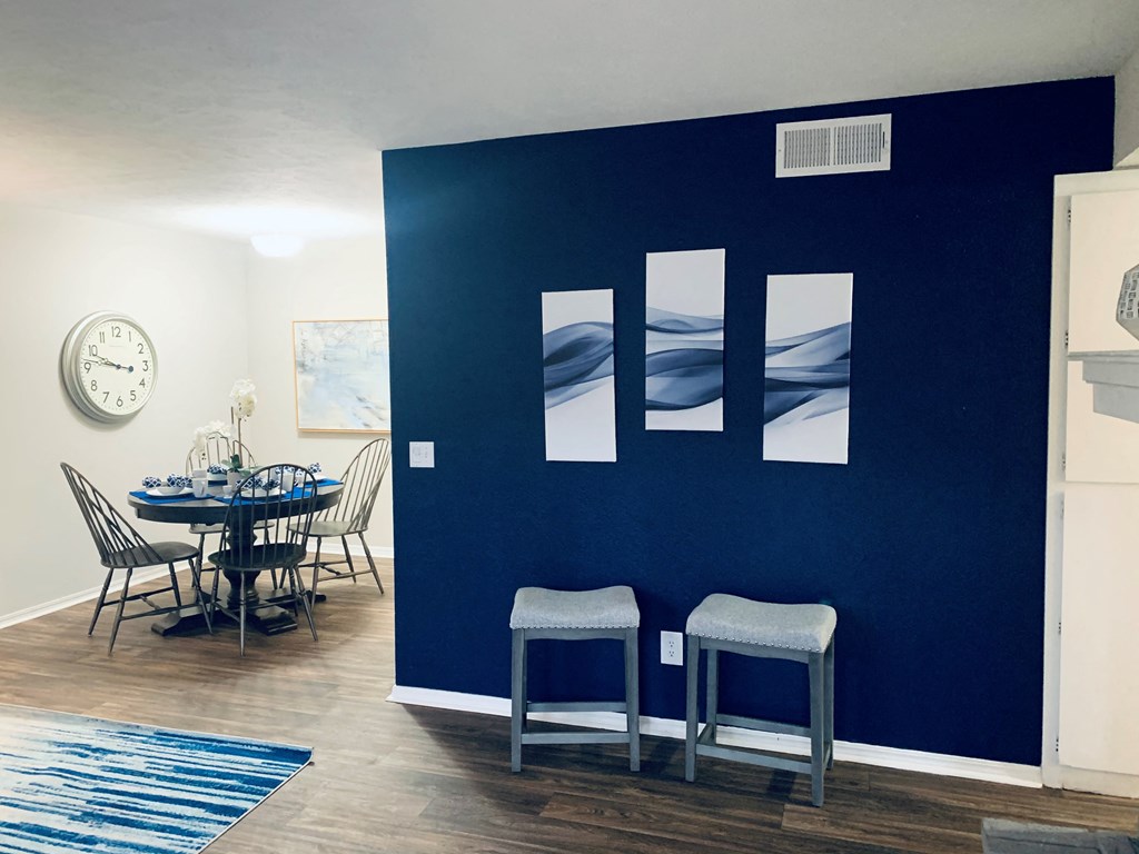 a dining room with a blue wall and a table and chairs