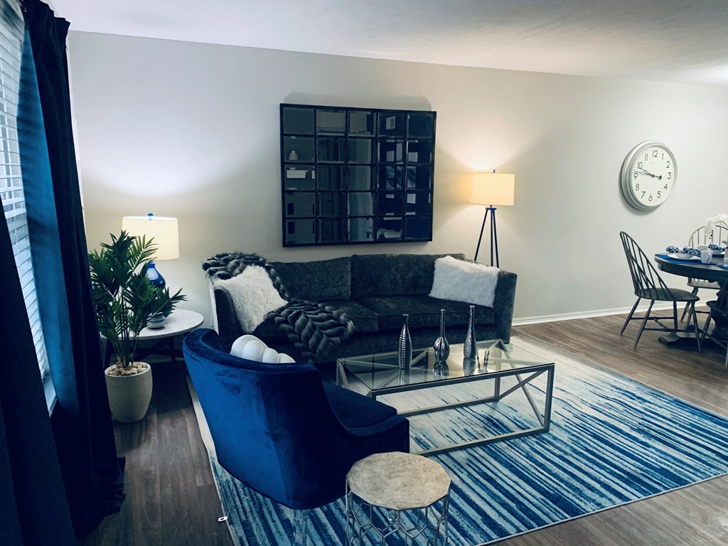 a living room with blue furniture and a blue rug