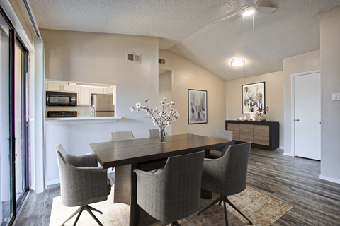 A dining room with a table and chairs.