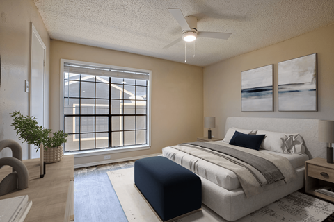 A bedroom with a large bed and a window with a view of a building.