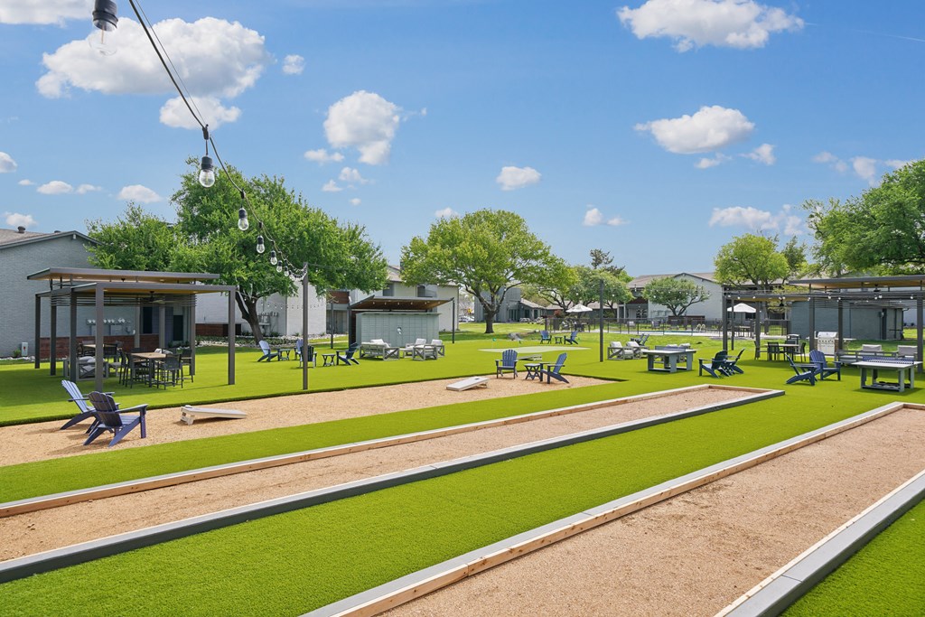 a rendering of a park with grass and tables and chairs
