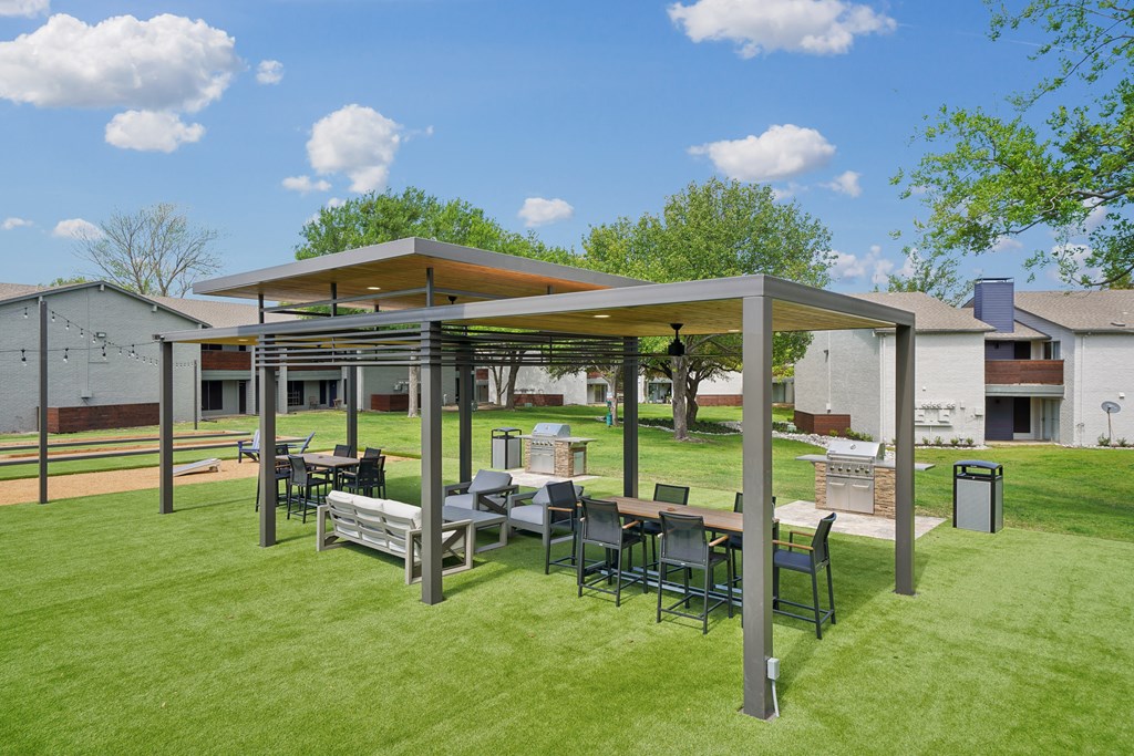 a patio with a table and chairs under a canopy