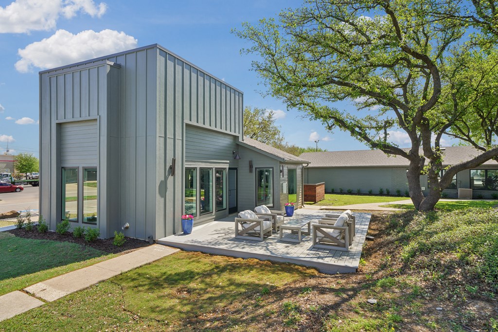 a patio with chairs and a table in front of a house