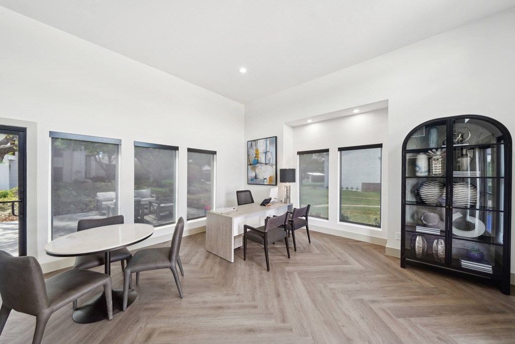 a dining room with a table and chairs and large windows