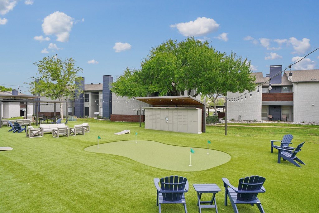 a yard with lawn chairs and a mini golf course