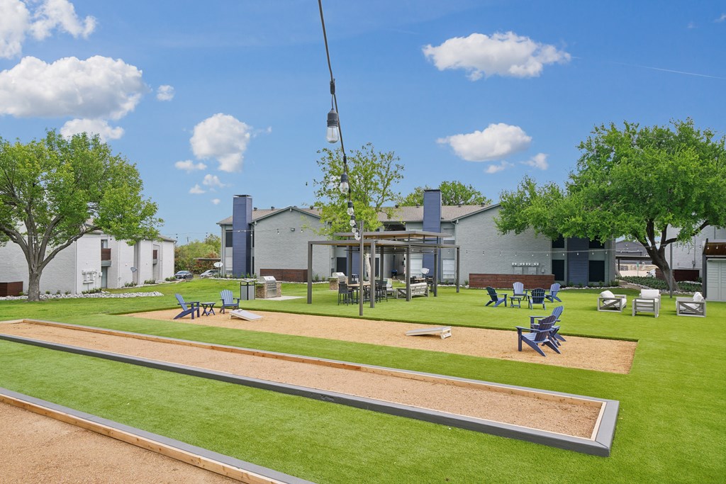 a park with a playground and picnic tables in front of a building