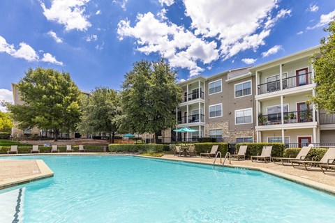 A swimming pool in front of apartment buildings.