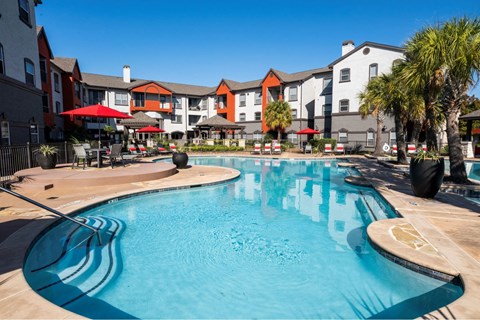 A large swimming pool in front of a resort.