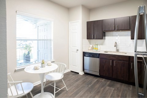 A kitchen with a white table and chairs is shown.