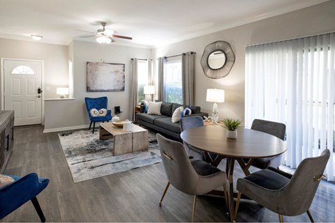 A living room with a grey sofa, a round table and a blue chair.
