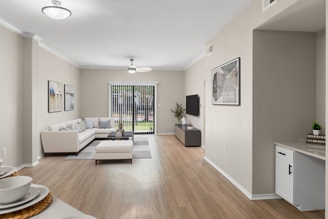 A living room with a white couch and a wooden floor.