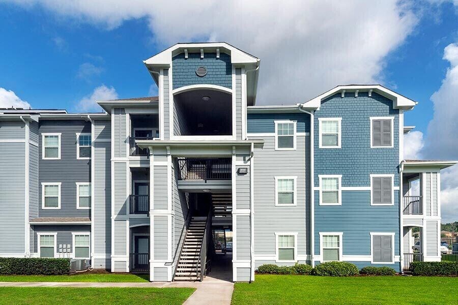 a blue apartment building with stairs and a blue sky