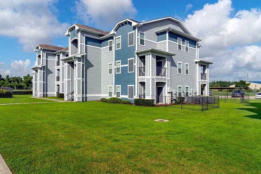 a blue house with a green lawn in front of it