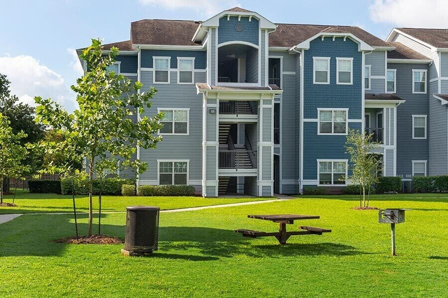 an apartment building with a picnic table in front of it