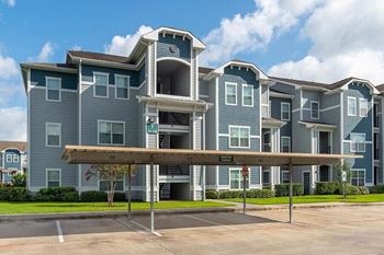 an apartment building with a parking lot in front of it