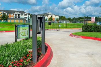 a parking lot with a sign in front of some houses