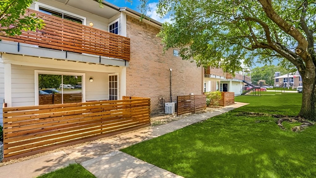 the side of a house with a yard and a wooden fence  at Creek on Calloway, Richland Hills, TX