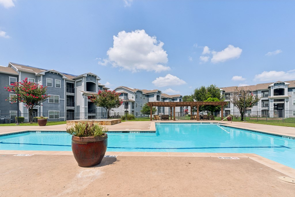 a large swimming pool with apartments in the background