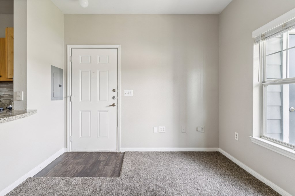 an empty room with a white door and a window