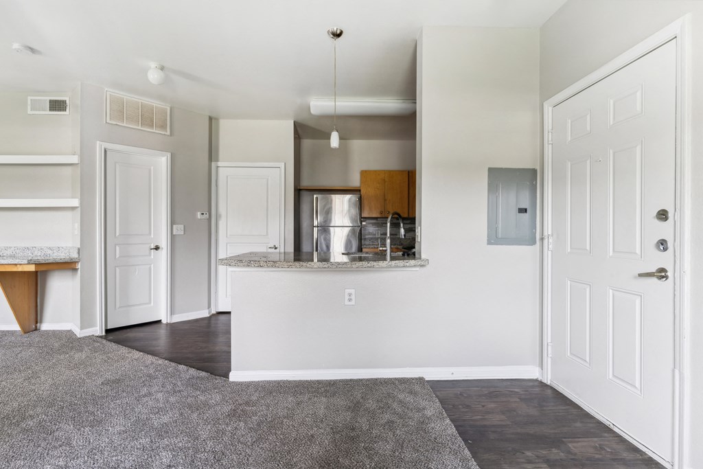 an empty living room and kitchen with white doors