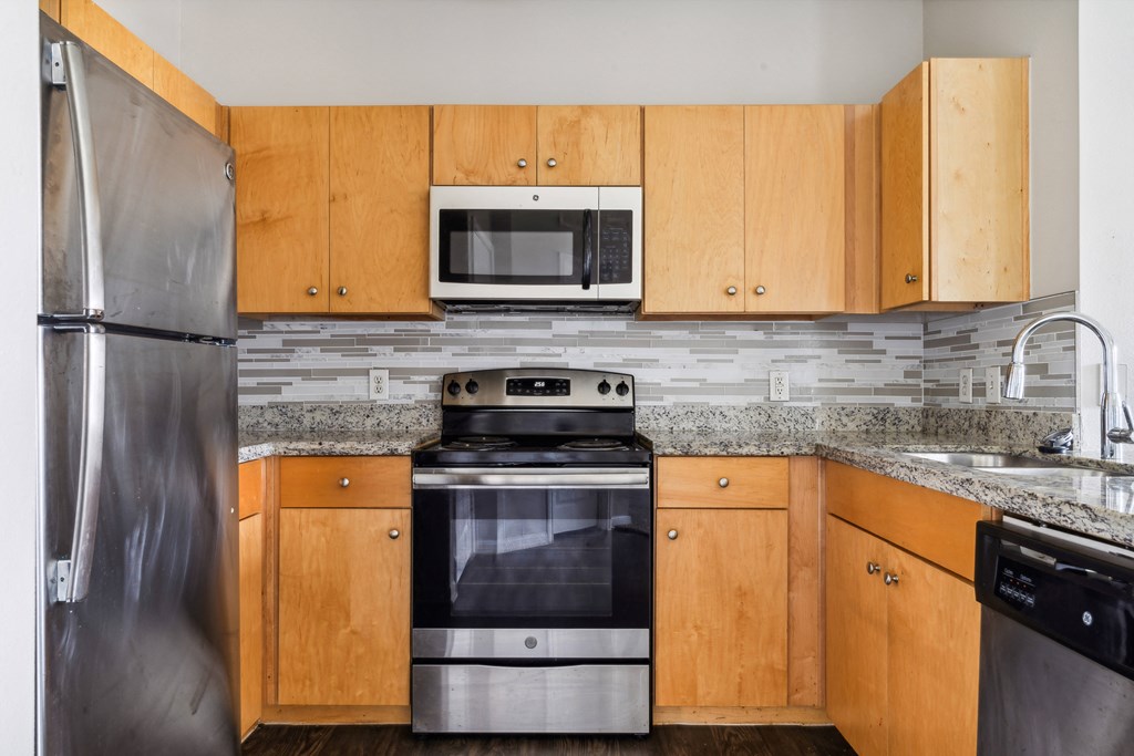 a kitchen with wooden cabinets and stainless steel appliances