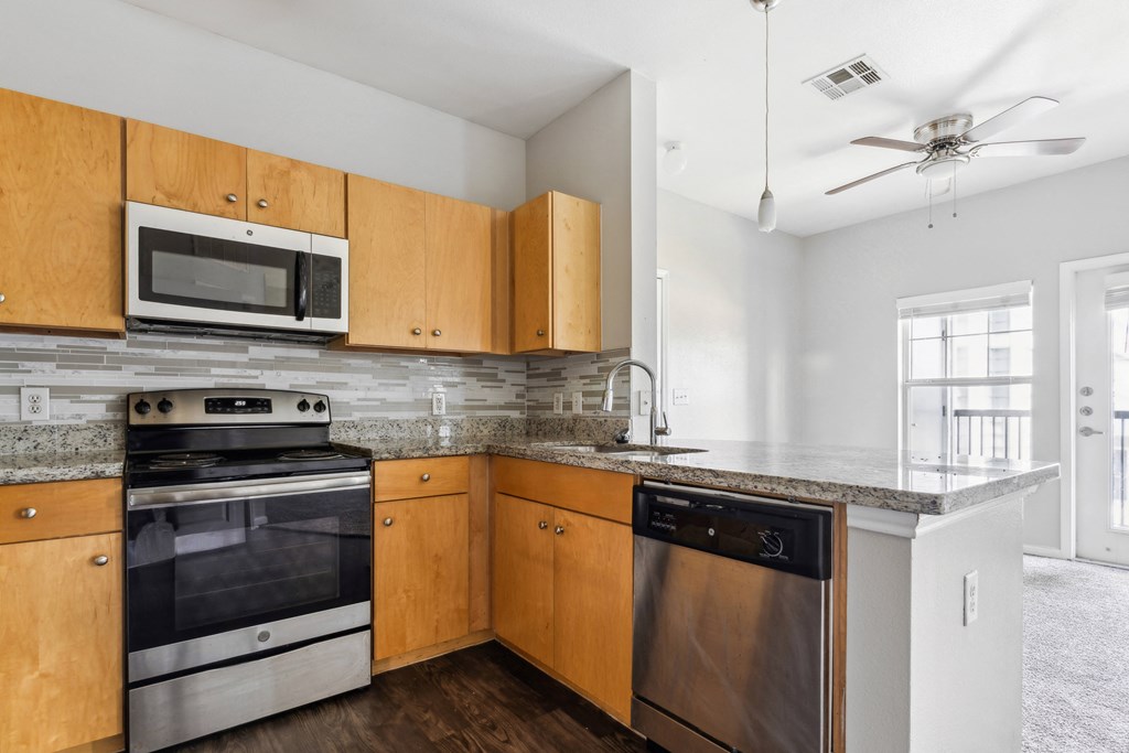 an empty kitchen with wooden cabinets and stainless steel appliances