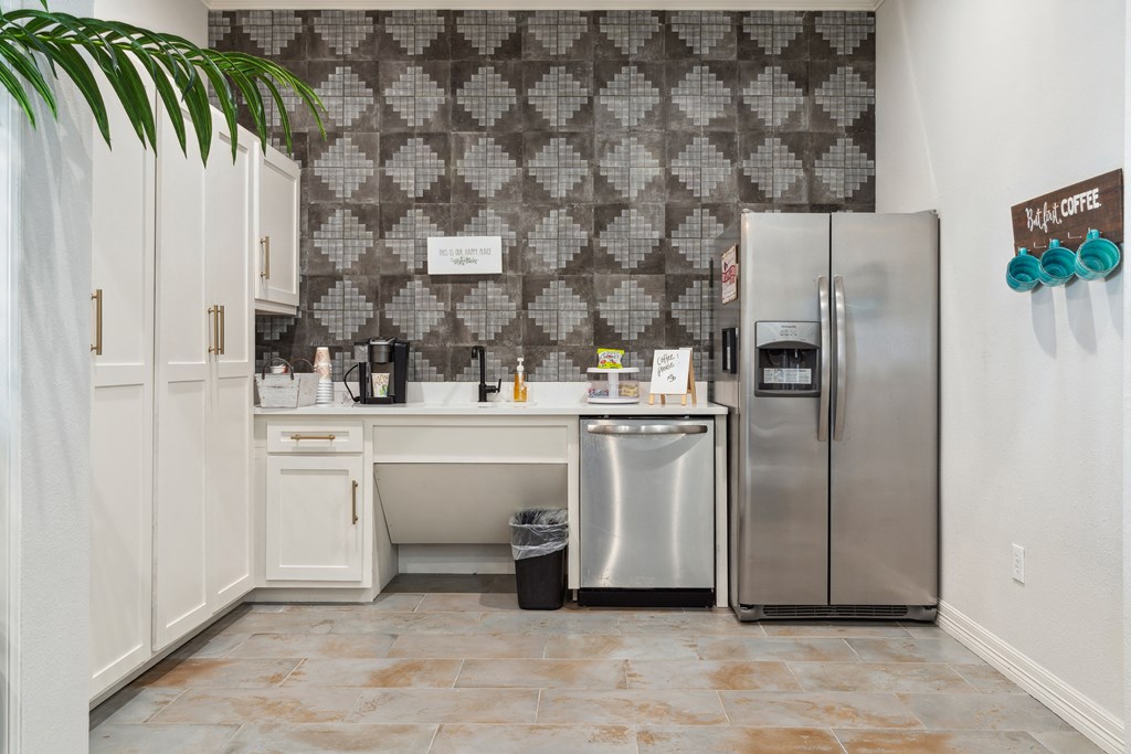 a white kitchen with a stainless steel refrigerator and sink