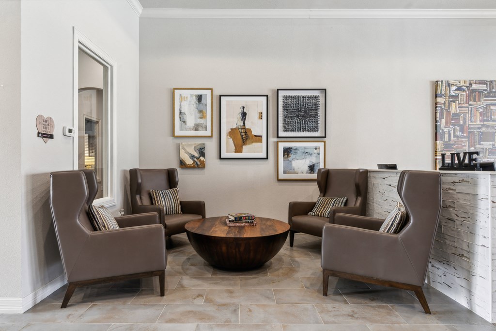 a living room with brown chairs and a table