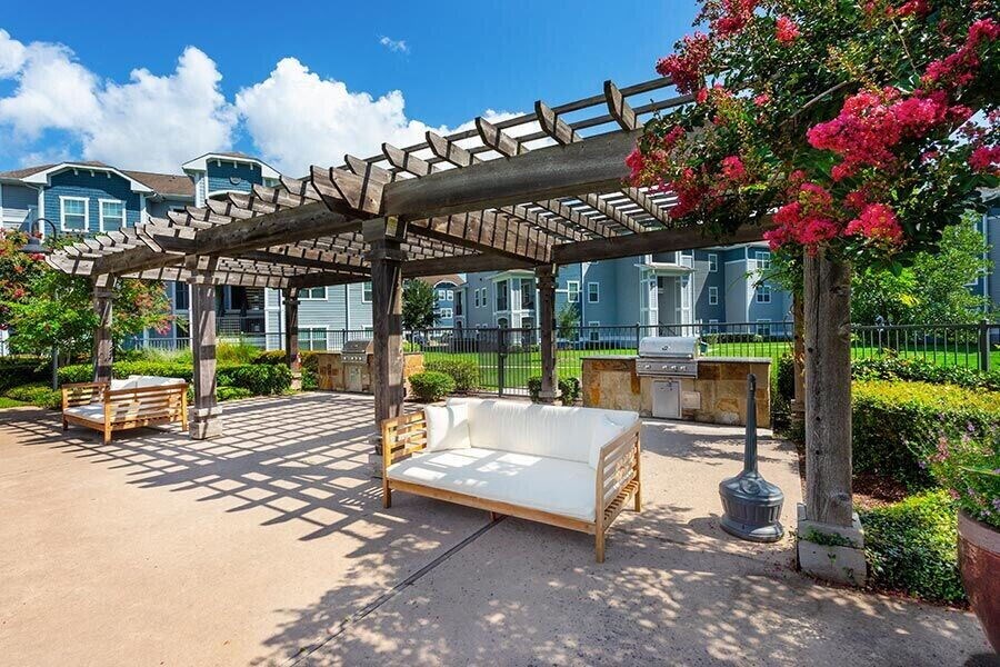 a bench sitting under a wooden canopy in a park