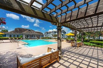 a swimming pool with benches and a pergola