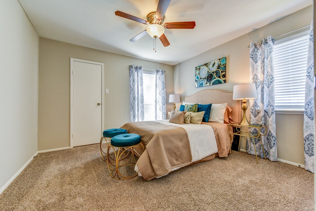 a bedroom with a large bed and a ceiling fan