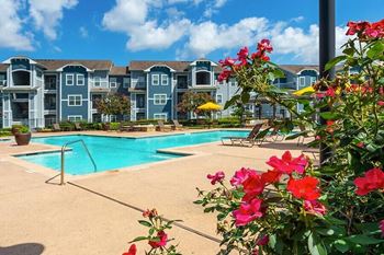 a swimming pool with an apartment building in the background