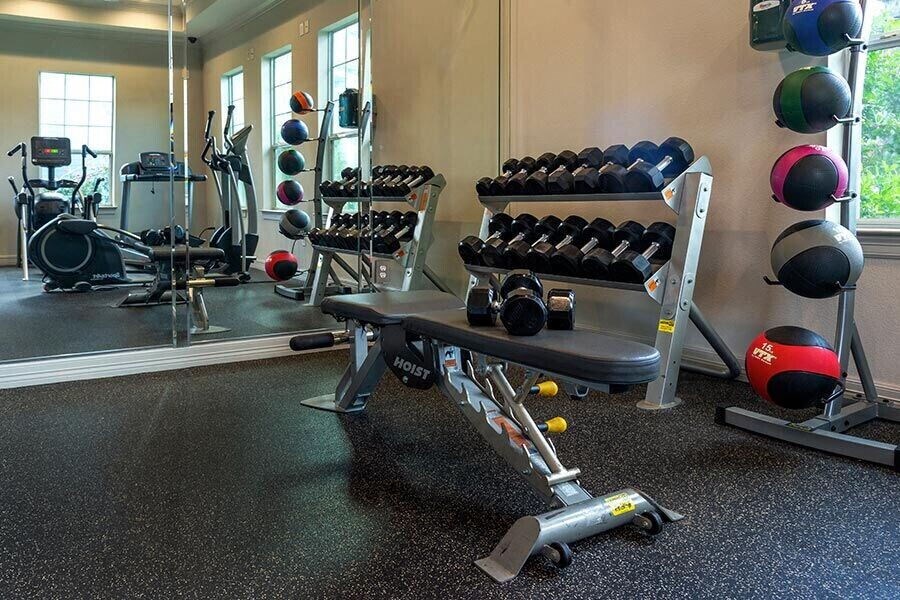 a gym with weights and a bench in it