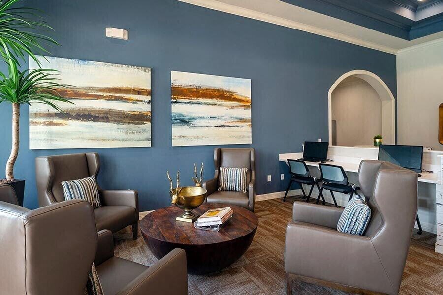 a living room with blue walls and chairs and a table