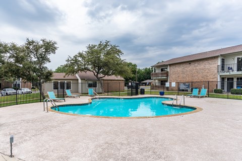 Outdoor swimming pool with deck chairs at Creek on Calloway Apartments, Texas, 76118