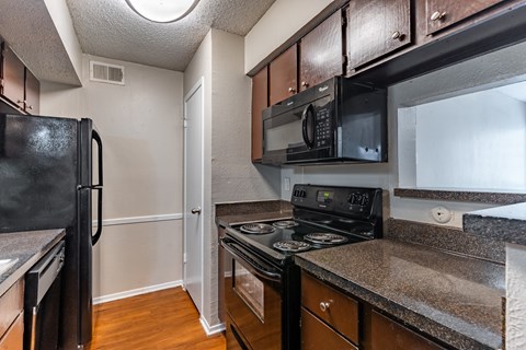 a kitchen with black appliances and granite counter tops
