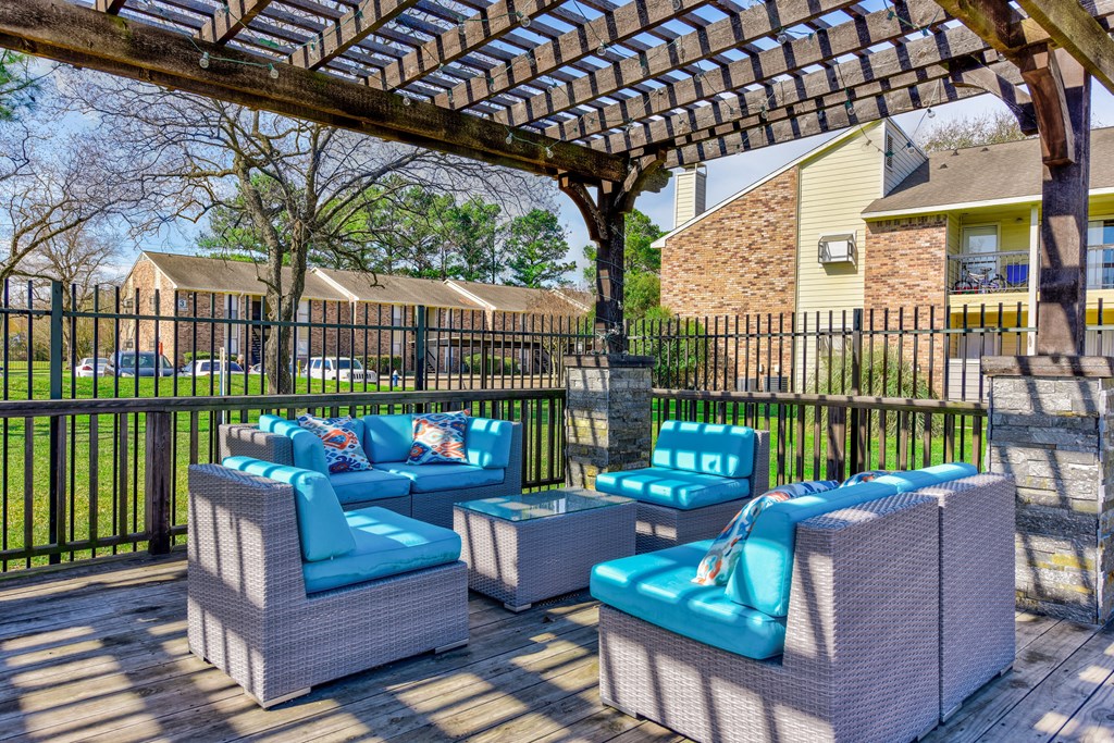 a patio with blue chairs and a pergola