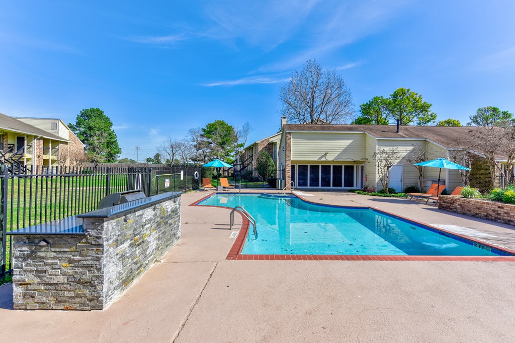 a swimming pool with a fence and a house in the background