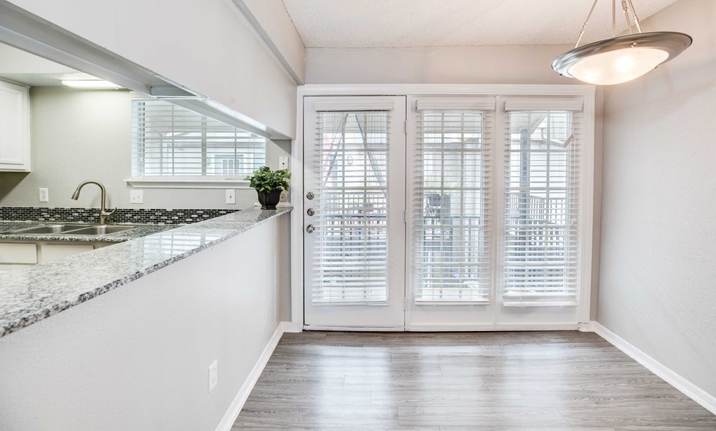 A kitchen with a marble countertop and white cabinets.
