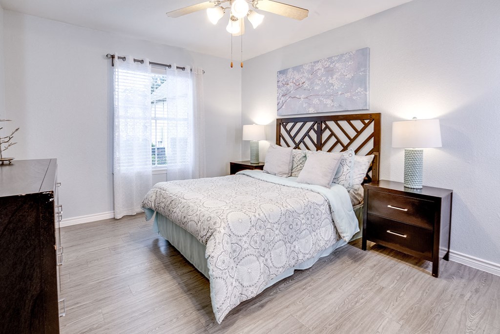 A bedroom with a large bed and a ceiling fan.