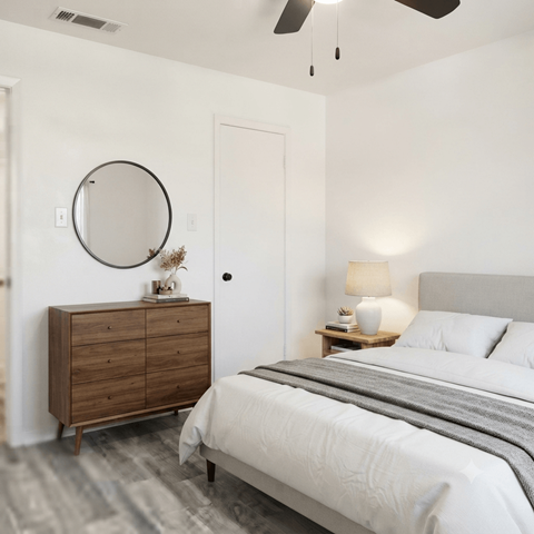 A bedroom with a bed, dresser, and mirror.