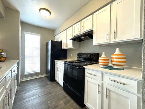 a kitchen with black appliances and white cabinets