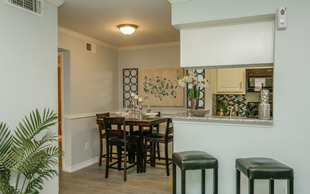 A dining room with a table and chairs.