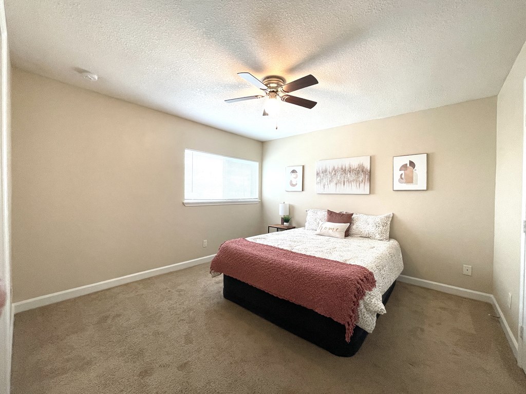 a bedroom with a bed and a ceiling fan