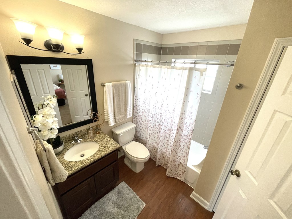 A bathroom with a sink, toilet, and shower.