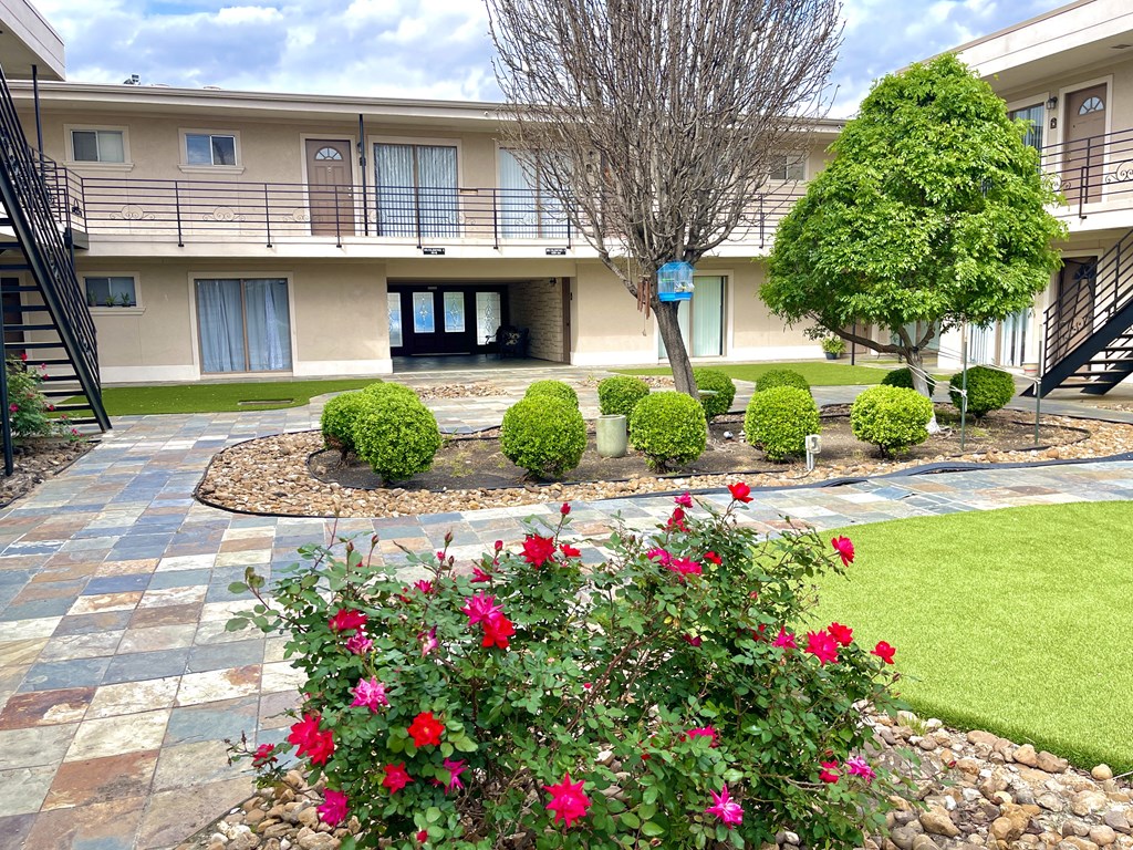 a building with a courtyard and flowers in front of it