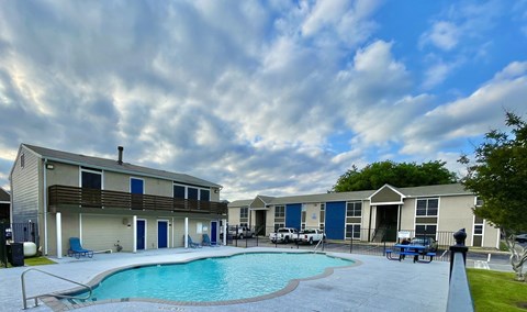 Swimming pool area with apartment buildings at Wymberly Crossing Apartments, Grand Prairie, Texas