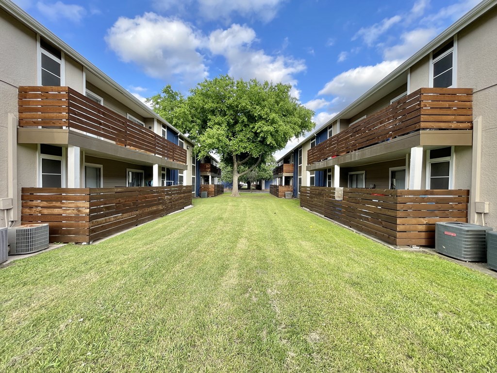 a yard in the middle of a row of apartment buildings