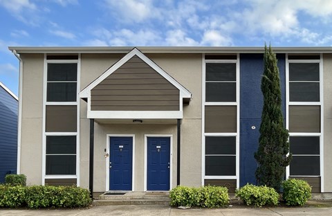 Two story apartment building with blue entrance doors at Wymberly Crossing Apartments, Texas